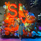 Woman posing in front of a large, colorful sugar land  sign with balloons and decorations.